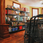 Foreground: shopping carts Background: stocked shelves with groceries inside Nourish House Food Bank