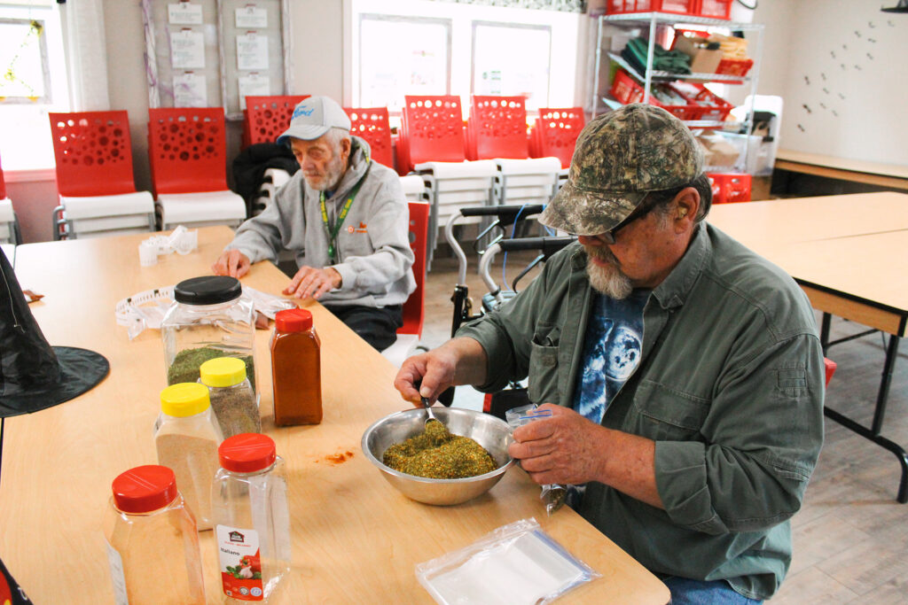 Two volunteers blend spices