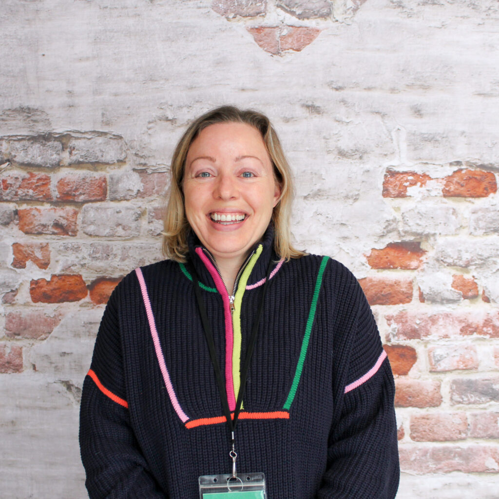 Headshot of Lisa, our Food Access Assistant, posing in front of a brick wall.