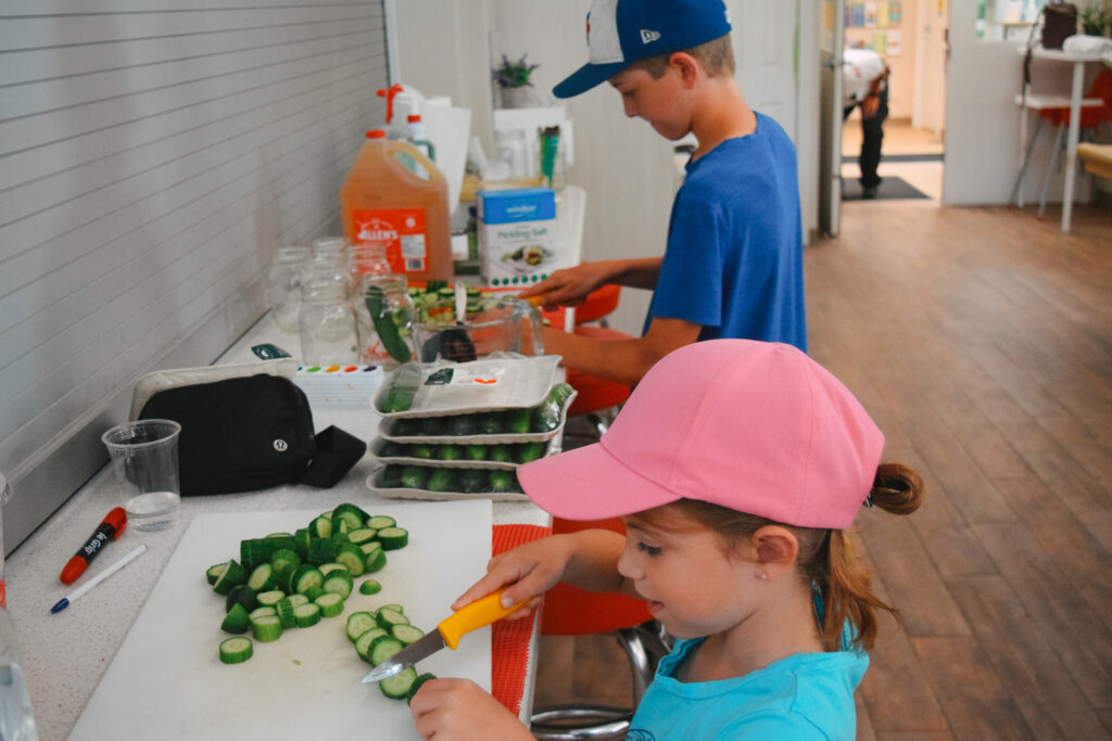 Kids of our Summer Camp chop cucumbers for homemade pickles.