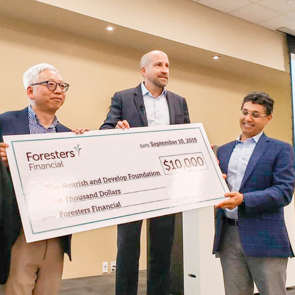 3 men from Foresters Financial holding up a cheque for $10,000