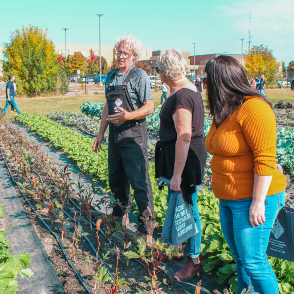 Kori and Jenn converse with a farmer at Durham College's Barrett centre