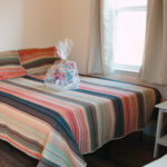 bed made with welcome basket ontop