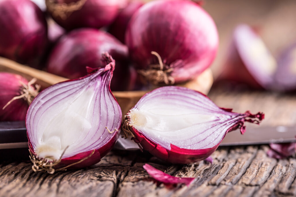 Onion. Red onions on very old oak wood board. Selective focus.