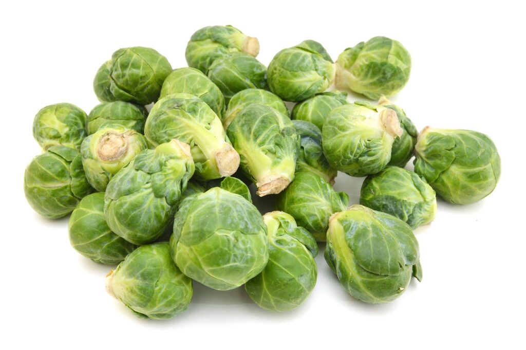 freshly brussel sprouts and some whole ones on a white background