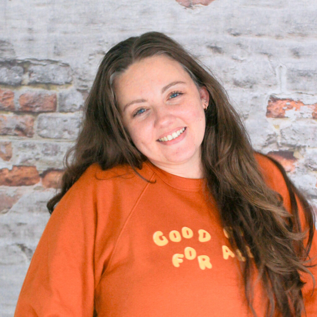 Headshot of Tiff, our Markets Coordinator, in front of a brick wall.