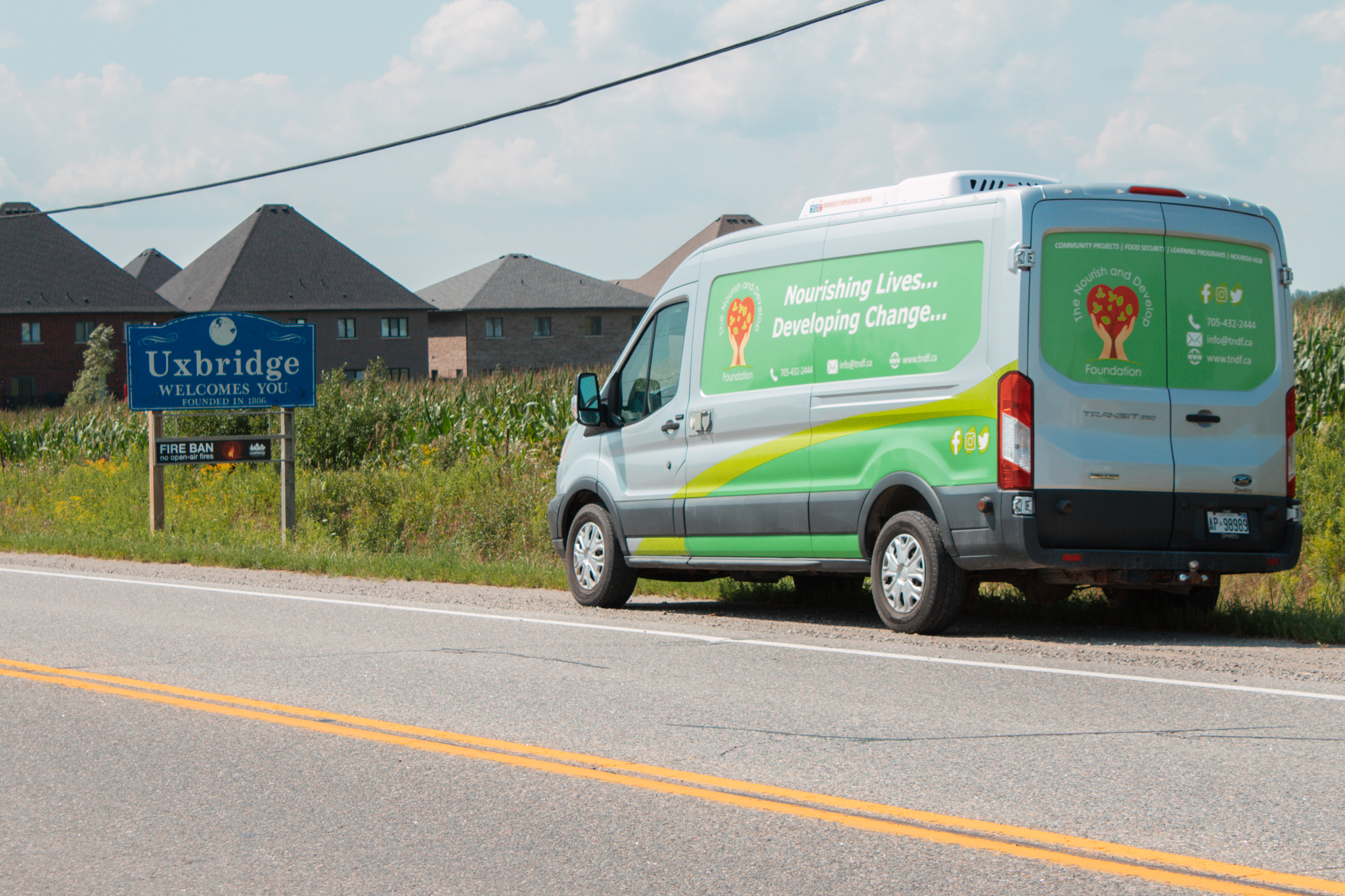 Our Mobile Food Market van in front of the Uxbridge town sign