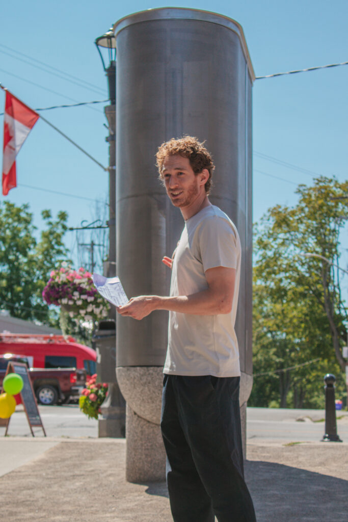Max Fine giving a speech in front of the battery